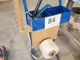 un chariot bleu contenant des outils et un rouleau de ruban adhésif