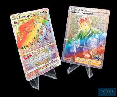 Deux cartes Pokémon sont exposées sur un présentoir, sur fond noir.