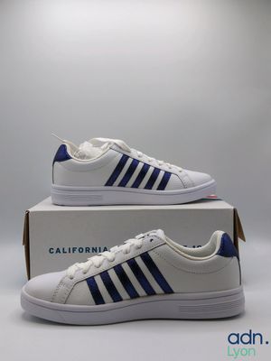 a pair of white and blue sneakers on a box