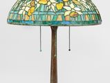 une lampe dont l'abat-jour en vitrail repose sur un socle en bois