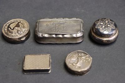 Plusieurs objets en argent sont disposés sur une table devant un fond noir