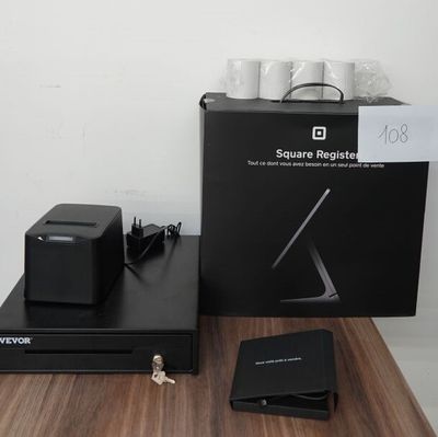 une boîte noire posée sur une table en bois, à côté d'un ordinateur portable et d'autres objets