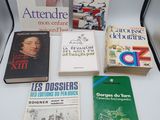 several books are sitting on a white table next to a lamp