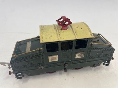 un petit train avec un toit jaune posé sur une surface blanche