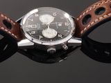a close up of a watch with a leather strap