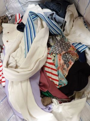 a pile of clothes that is on a bed