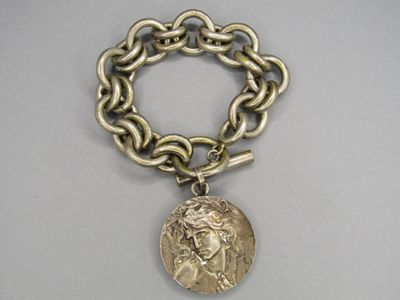 une photo d'un bracelet auquel est attachée une pièce de monnaie