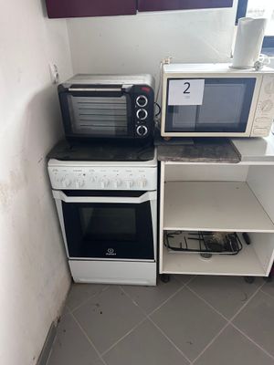 two microwaves and a toaster oven in the corner of a kitchen
