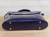 the small blue purse is sitting on a wooden table
