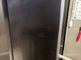 a stainless steel refrigerator in the corner of a kitchen