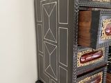 a black and gold chest of drawers with a clock on top