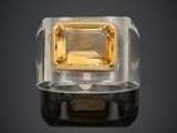 une bague sertie d'un saphir jaune sur un fond noir
