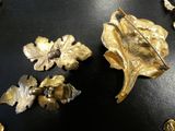 some gold brooches and a pin on a black table