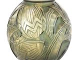 un vase vert orné d'un motif sur fond blanc