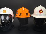 three different types of fire hats on display against a black background