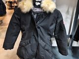a black jacket with a fur collar on display in a store