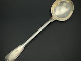 une cuillère ancienne en argent dont le manche repose sur une surface noire