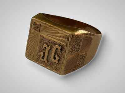 gros plan d'une bague en or sur une surface blanche