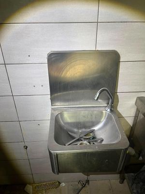 un lavabo en métal dans une salle de bains, équipé d'un robinet en métal