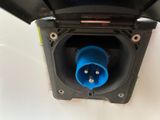an overhead view of a black electrical outlet with a blue plug