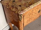 a small wooden table with a marble top on a carpeted floor