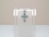 a small clear box with a cross on top of it