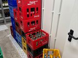 several crates of soda are stacked on the floor in front of a door