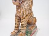 une petite statue représentant un tigre sur un skateboard