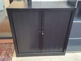 une armoire noire à deux portes, munie d'une poignée de porte