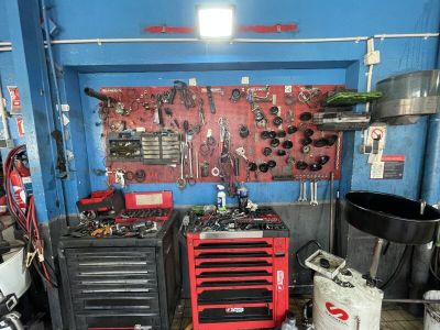 un garage rempli d'outils, dont certains sont accrochés au mur