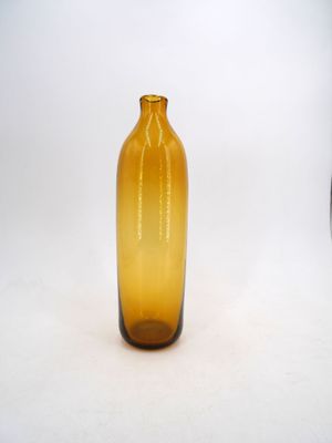 a yellow glass bottle that is sitting on a white surface