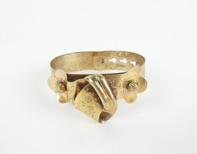 gros plan d'une bague en or sur une surface blanche