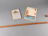 a cane, a book, and a card on a table