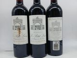 trois bouteilles de vin rouge posées sur une table blanche