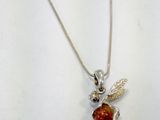 silver plated necklace with an orange glass fairy sitting on top of a white surface