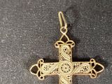 a close up of a gold cross on a black cloth