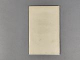 an old book sitting on top of a table next to a white object