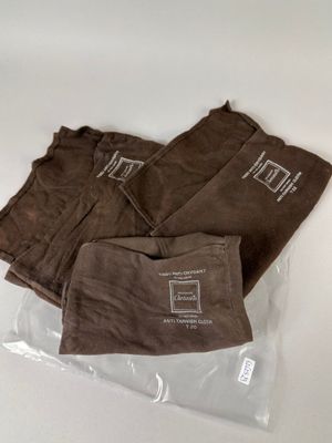 three pairs of brown pants sitting on top of a plastic bag