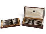 paire de couteaux plaqués argent dans un coffret en bois sur fond blanc