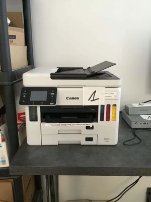 a printer sitting on top of a desk next to a printer