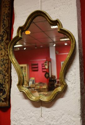 un miroir accroché au mur, à côté d'un mur rouge