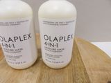 two bottles of olaplex 4 in 1 moisturizer on a cutting board