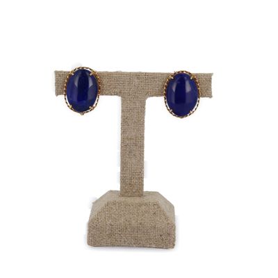 une paire de boucles d'oreilles en pierre bleue posées sur un présentoir