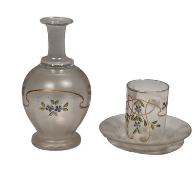 un vase en verre et un verre posés sur une assiette