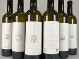 six bottles of wine are lined up in a row on a table