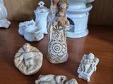 many figurines on a table with a teapot in the background