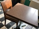 a small table and chair in a room with a checkered floor
