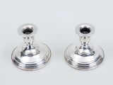 pair of silver candlesticks on a white background