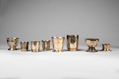 un ensemble de tasses et de coupes en argent posées sur une table