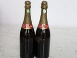 two bottles of champagne sitting on top of a marble counter top